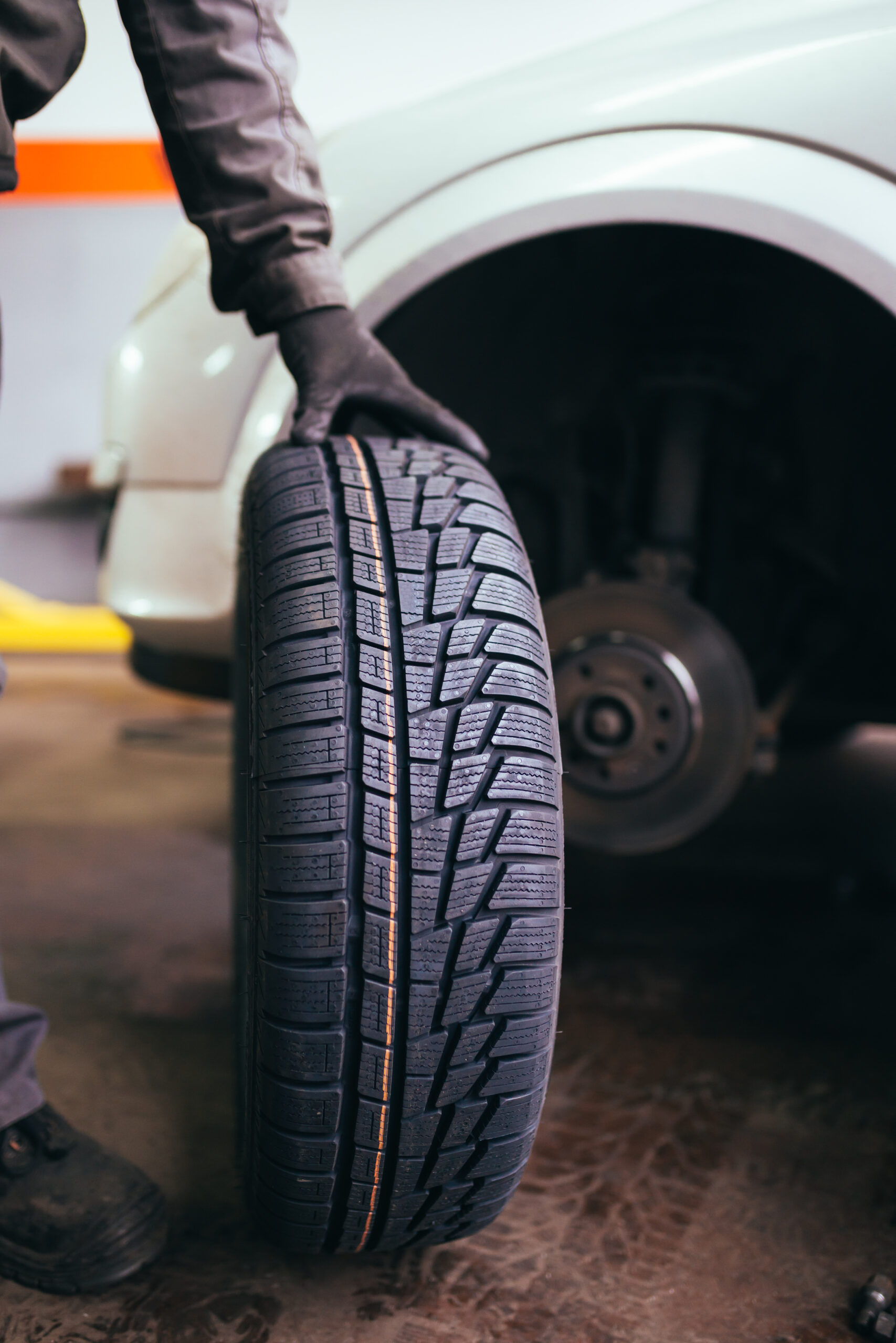 Auto mechanic changing wheel on car.